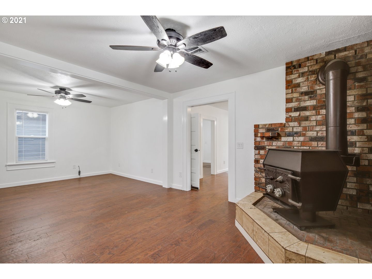 16946 Northwest St Helens Road Portland, OR 97231 - Photo 6 of 31 an empty room with wooden floor fan and windows