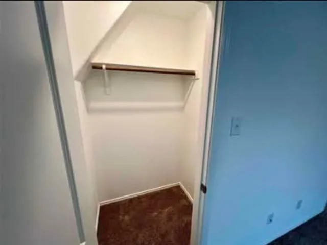 a view of an empty room and kitchen