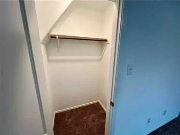 a view of an empty room and kitchen