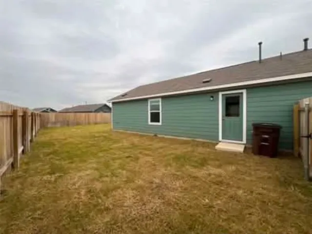 a view of an house with backyard space and balcony