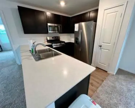 a kitchen with stainless steel appliances a refrigerator and a sink