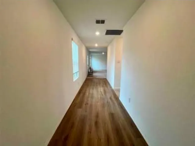 a view of a hallway with wooden floor