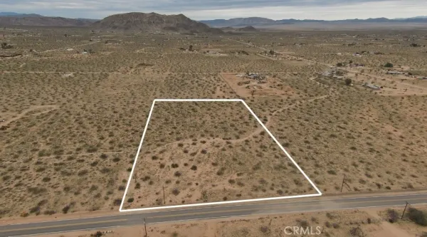 a view of a dry yard with mountains