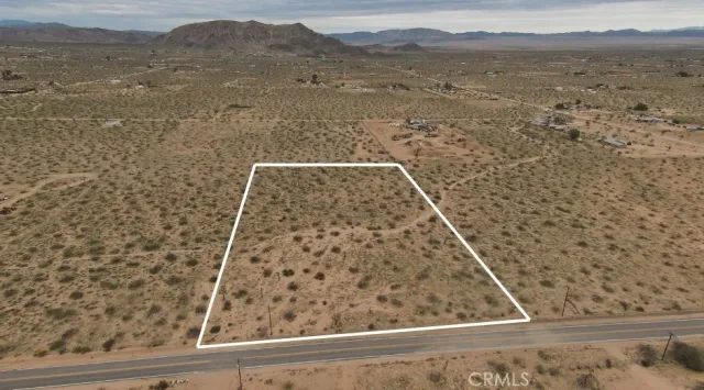 a view of a dry yard with mountains