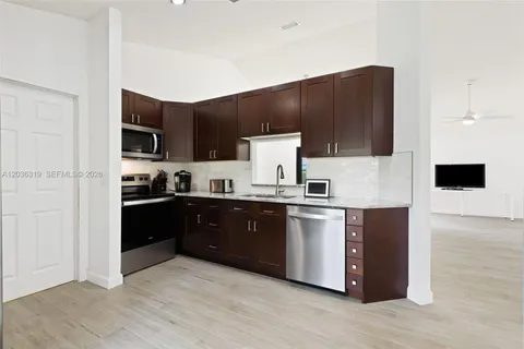 a kitchen with stainless steel appliances kitchen island granite countertop a refrigerator and a stove top oven