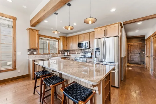 a kitchen with a refrigerator a sink and wooden cabinets