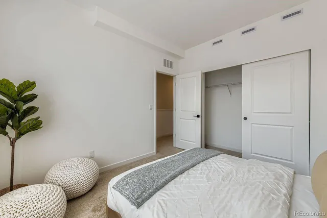 a bedroom with a bed and a potted plant