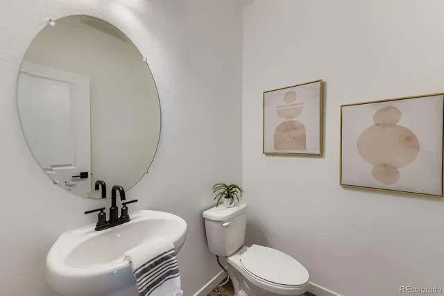 a bathroom with a toilet a sink and mirror