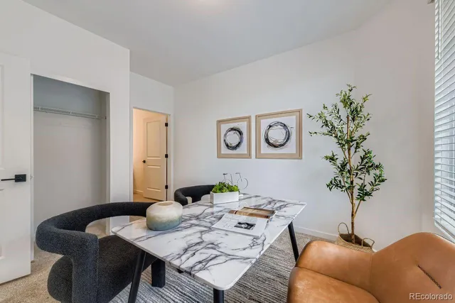 a view of a dining room with furniture and a potted plant