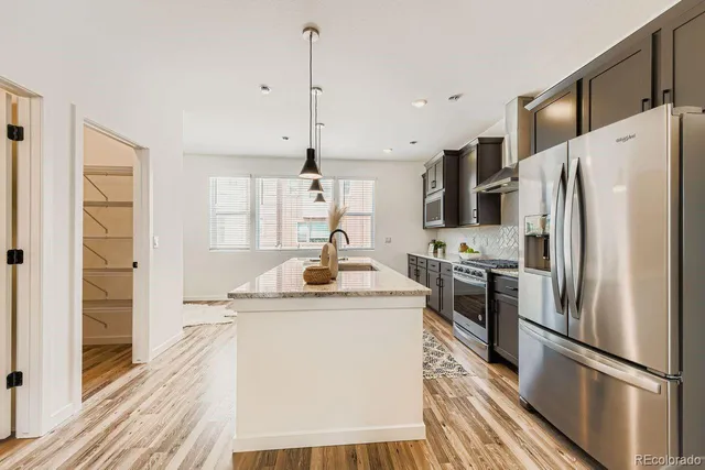 a kitchen with stainless steel appliances a refrigerator a sink a stove a microwave and island