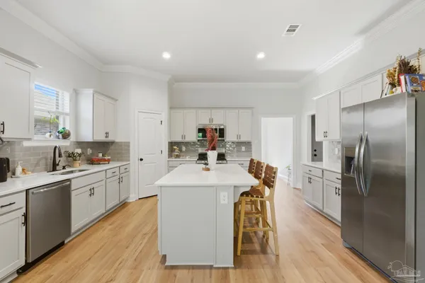 a kitchen with sink a refrigerator and wooden floor