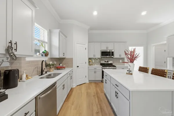 a kitchen with a sink stove top oven and refrigerator