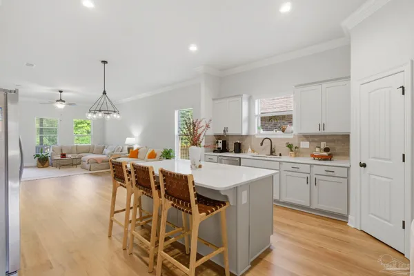 a kitchen with stainless steel appliances a dining table chairs stove and white cabinets