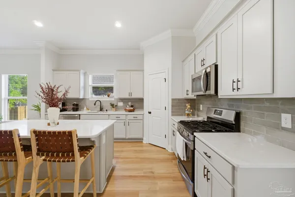 a kitchen with stainless steel appliances kitchen island granite countertop a stove a sink a microwave and a refrigerator