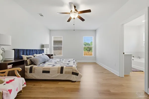 a bedroom with furniture and a ceiling fan