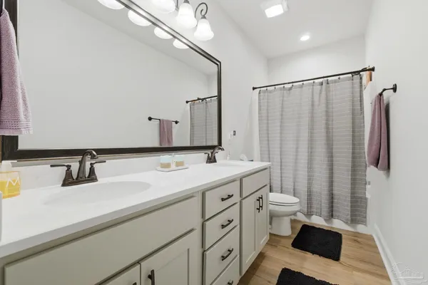 a bathroom with a double vanity sink toilet and shower