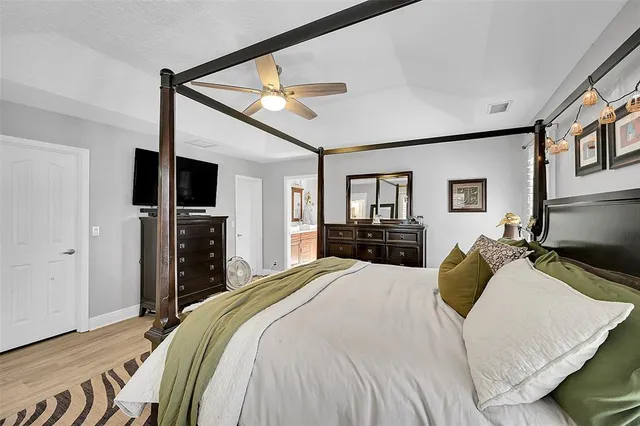a bedroom with a bed and wooden floor