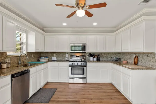 a kitchen with stainless steel appliances granite countertop a sink and cabinets