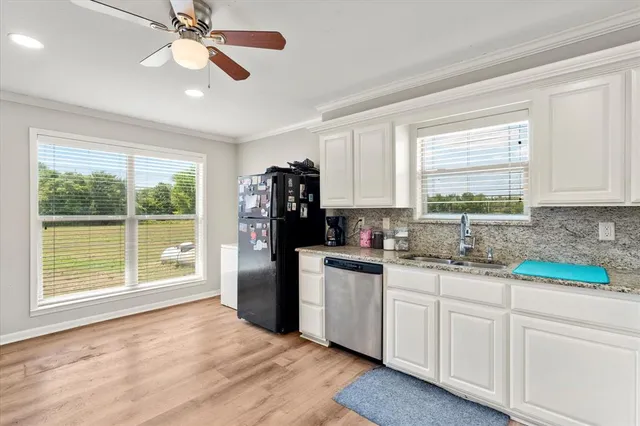 a kitchen with appliances cabinets and a large window