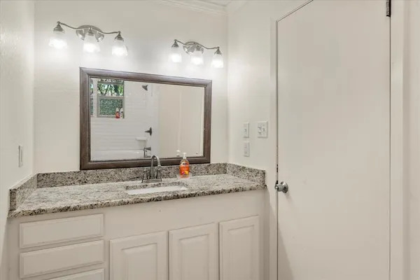 a bathroom with a granite countertop sink and a mirror