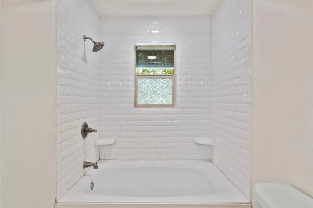 a bathroom with a bathtub and window