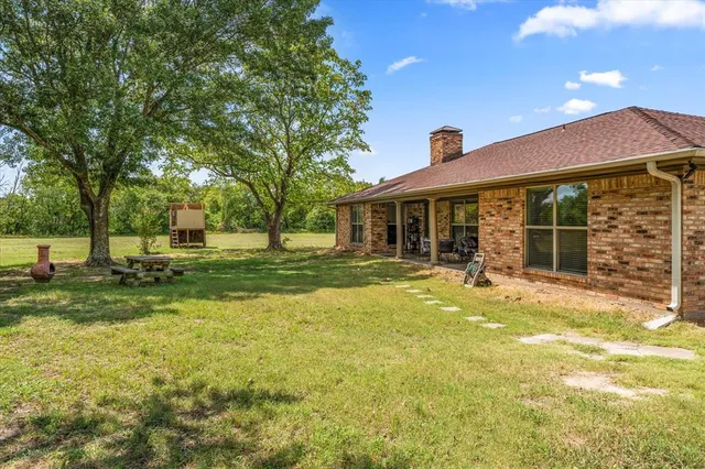 a view of a house with backyard and a tree