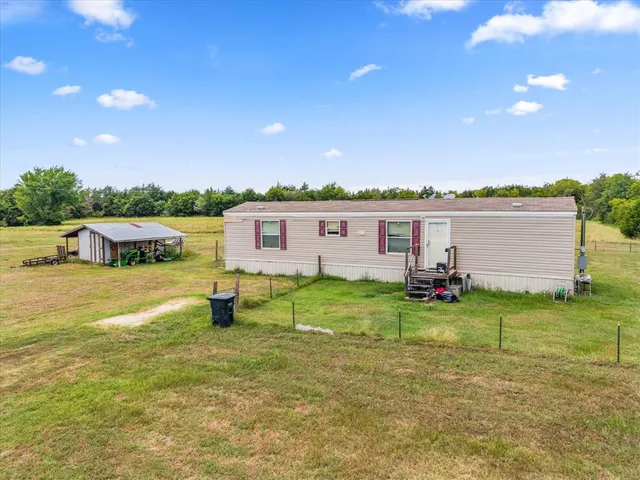 a view of a house with yard and a patio