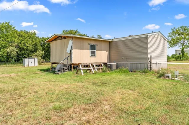 a backyard of a house with table and chairs