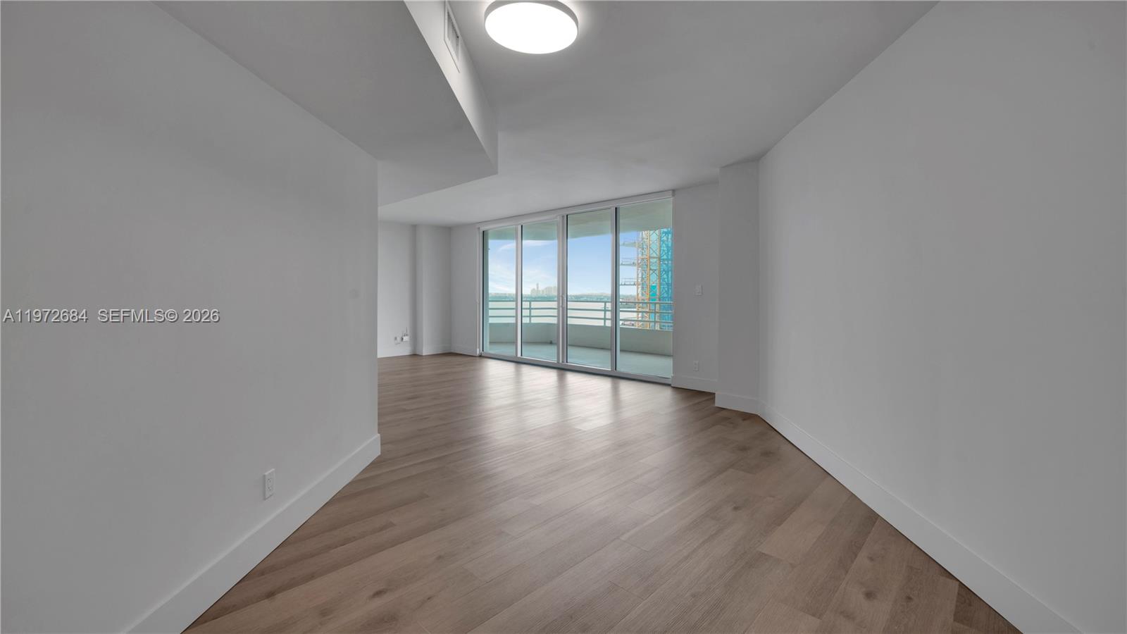 555 Northeast 34th Street, Unit 2607 Miami, FL 33137 - Photo 11 of 35 a view of wooden floor and windows in a room