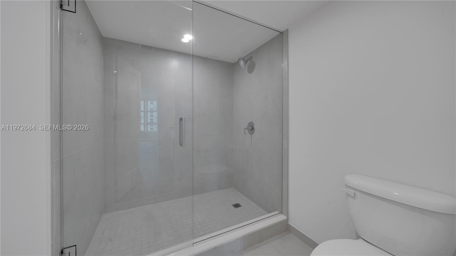 555 Northeast 34th Street, Unit 2607 Miami, FL 33137 - Photo 26 of 35 a bathroom with a shower and a toilet