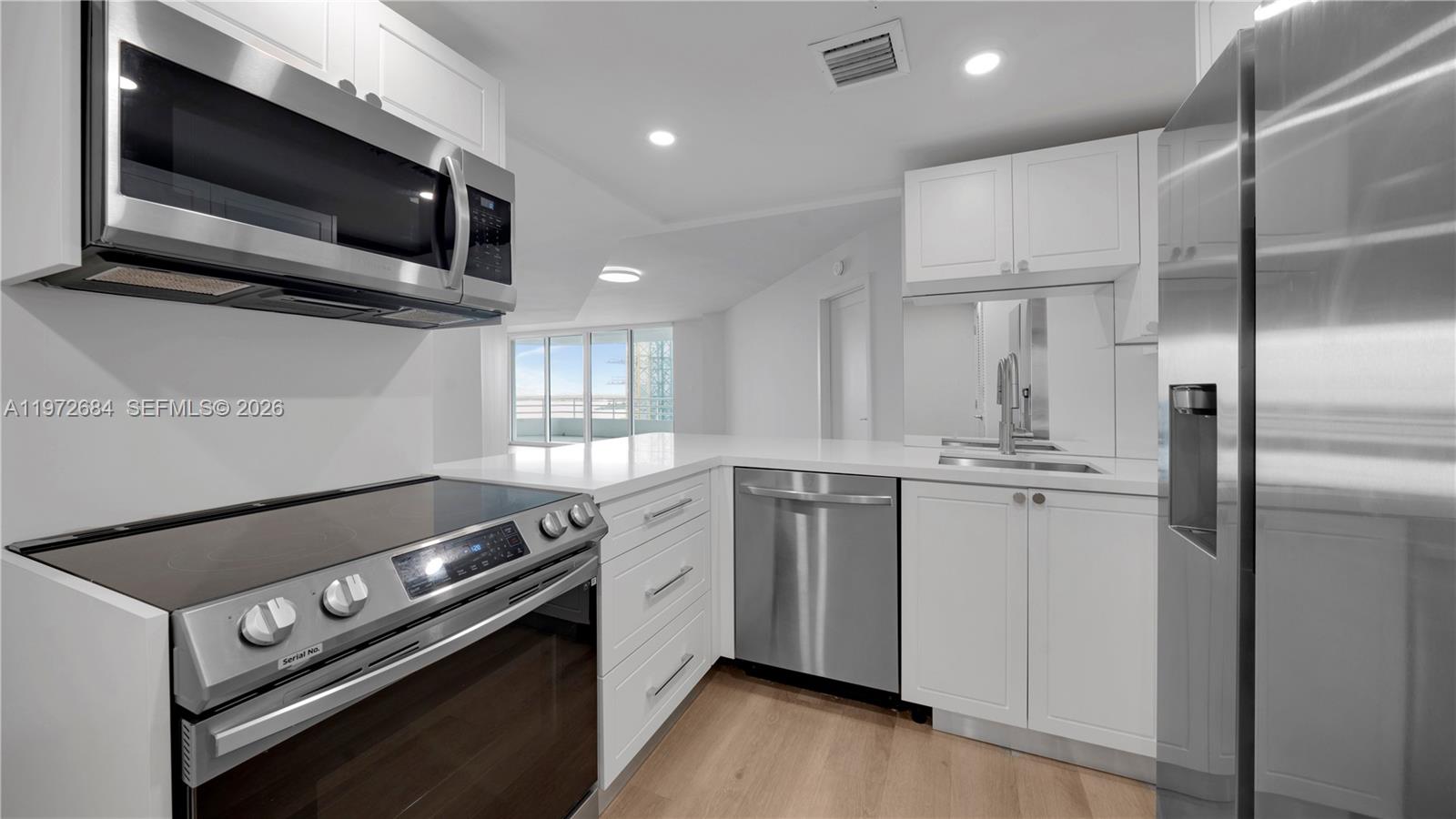 555 Northeast 34th Street, Unit 2607 Miami, FL 33137 - Photo 9 of 35 a kitchen with a stove and a microwave