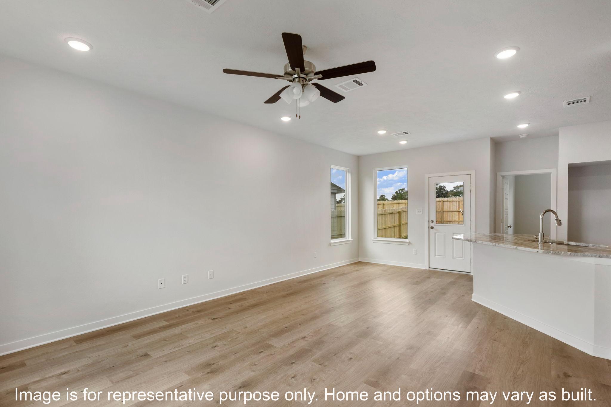 251 Gus Loop Georgetown, TX 78626 - Photo 4 of 10 Natural light cascades across a spacious open-concept living area with durable flooring and modern recessed lighting.
