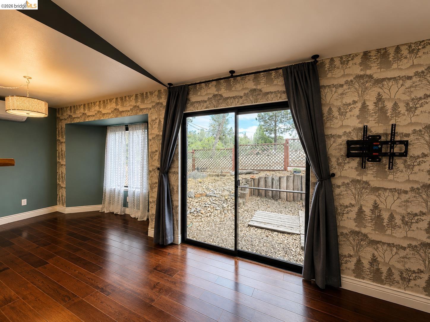 20663 Ferretti Road Groveland, CA 95321 - Photo 14 of 41 Hardwood flooring, sliding glass door, patterned accent wall, built-in shelf, and recessed window