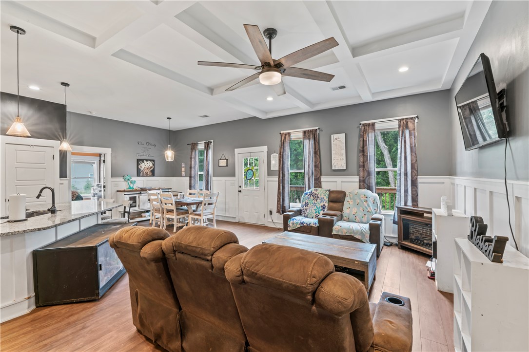 429 Nelson Drive Anderson, SC 29621 - Photo 8 of 32 Integrated living spaces combine dining, kitchen, and relaxation under a decorative tray ceiling with a modern ceiling fan.