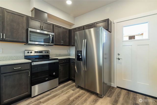 a kitchen with stainless steel appliances granite countertop a refrigerator and a stove top oven