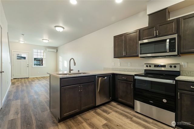 a kitchen with stainless steel appliances a stove sink and microwave