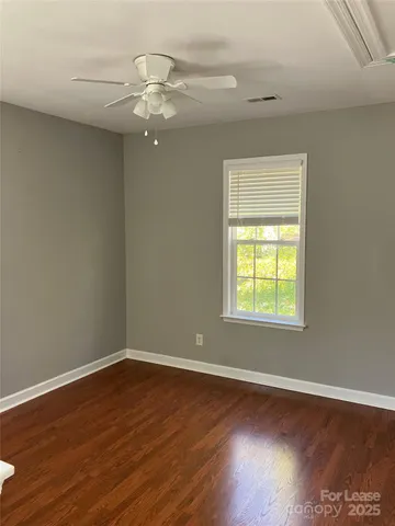 a view of wooden floor chandelier and window in a room