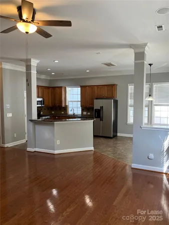 a view of kitchen with refrigerator stove and wooden floor
