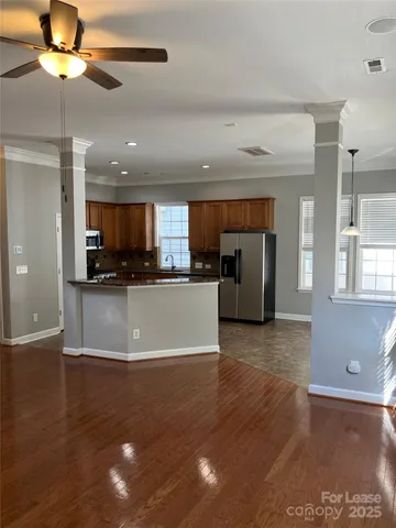 a view of kitchen with refrigerator stove and wooden floor