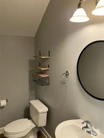 a bathroom with a toilet a sink and mirror