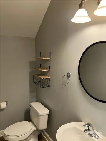 a bathroom with a toilet a sink and mirror