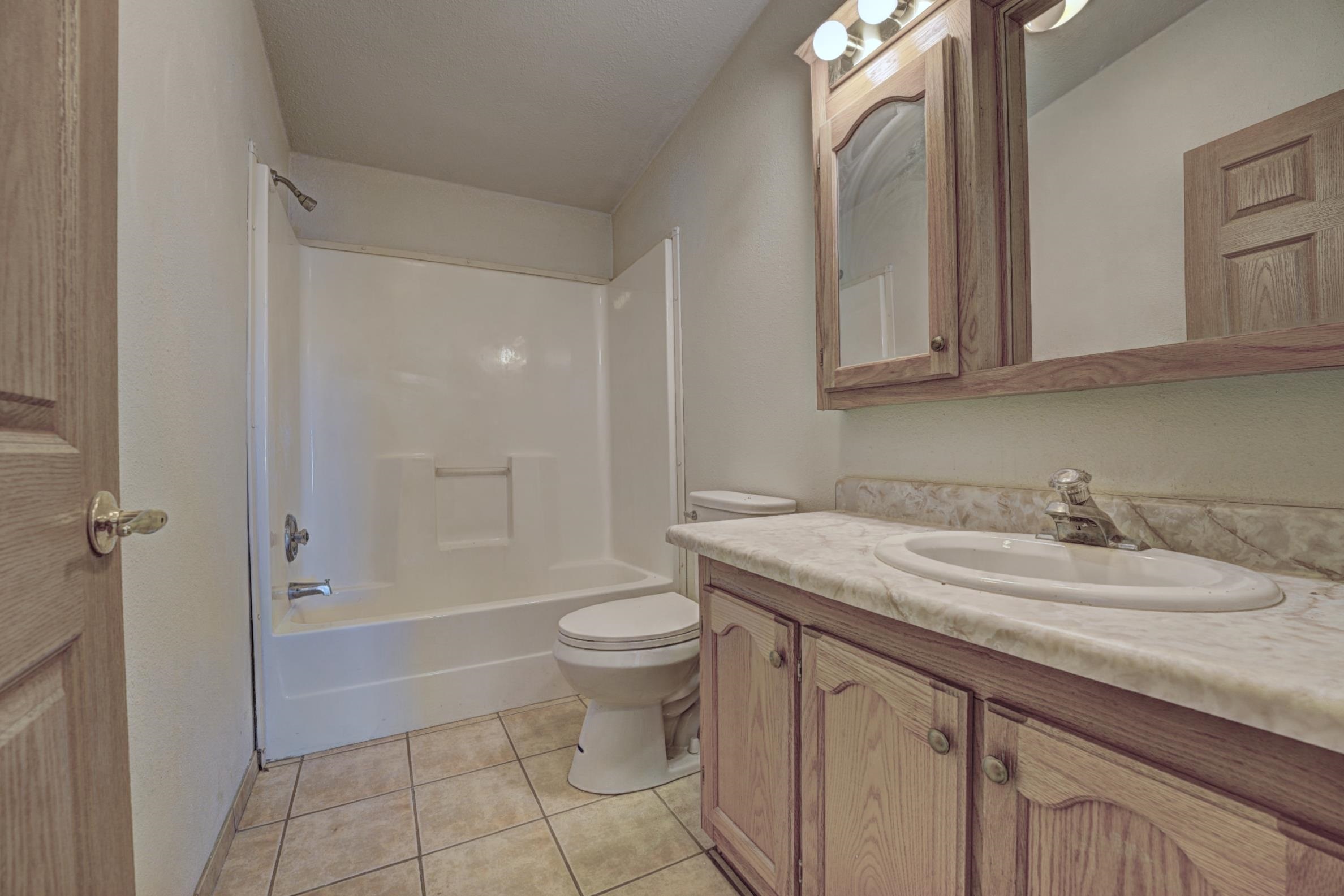 694-29 29 1/2 Road Grand Junction, CO 81504 - Photo 19 of 27 a bathroom with a granite countertop sink a toilet and shower
