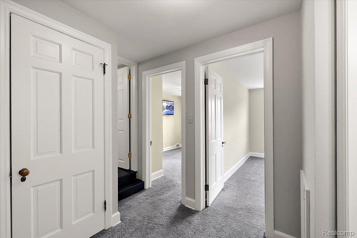 1051 Devonshire Road Grosse Pointe, MI 48230 - Photo 52 of 99 Hallway featuring light gray wall paint, contrasting white trim, and gray carpet flooring