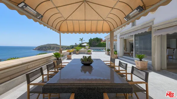 a view of a patio with table and chairs and potted plants