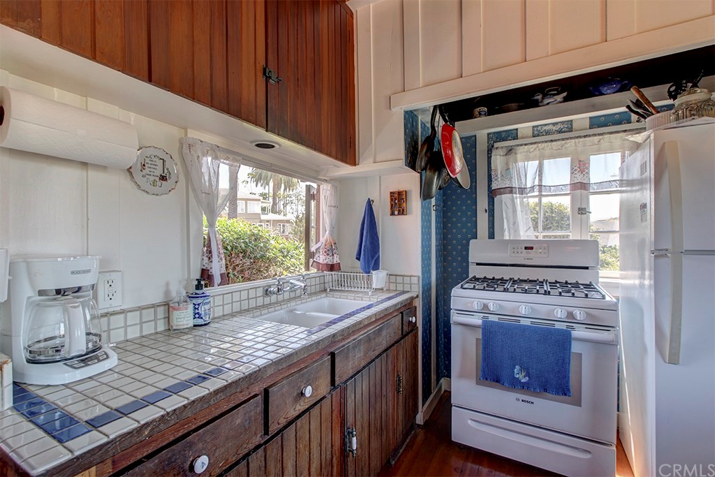 310 Hawthorne Road Laguna Beach, CA 92651 - Photo 13 of 25 a kitchen with stainless steel appliances granite countertop a stove a sink and a microwave
