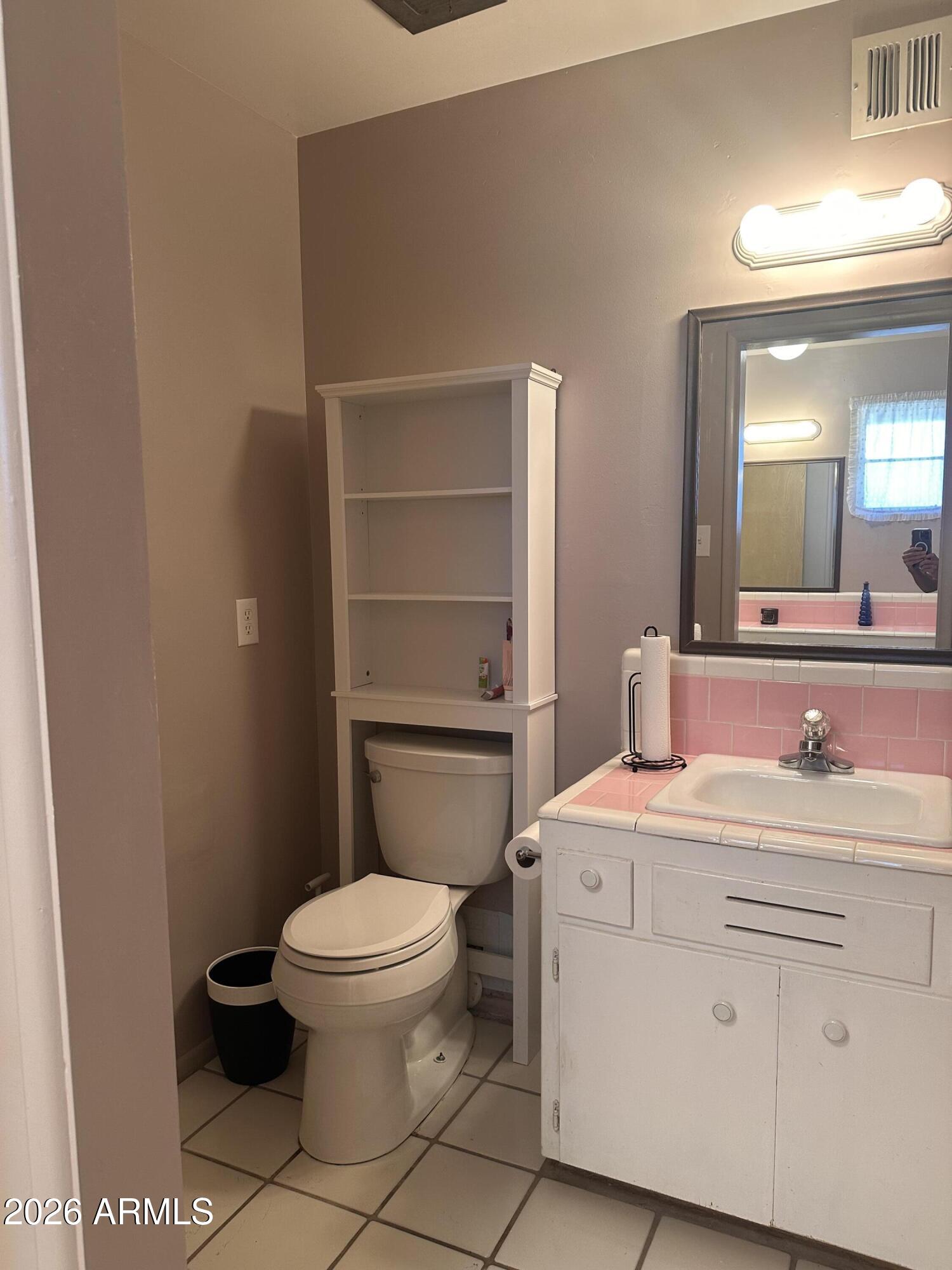 2821 West Elliot Road Laveen, AZ 85339 - Photo 39 of 92 a bathroom with a granite countertop toilet sink and mirror
