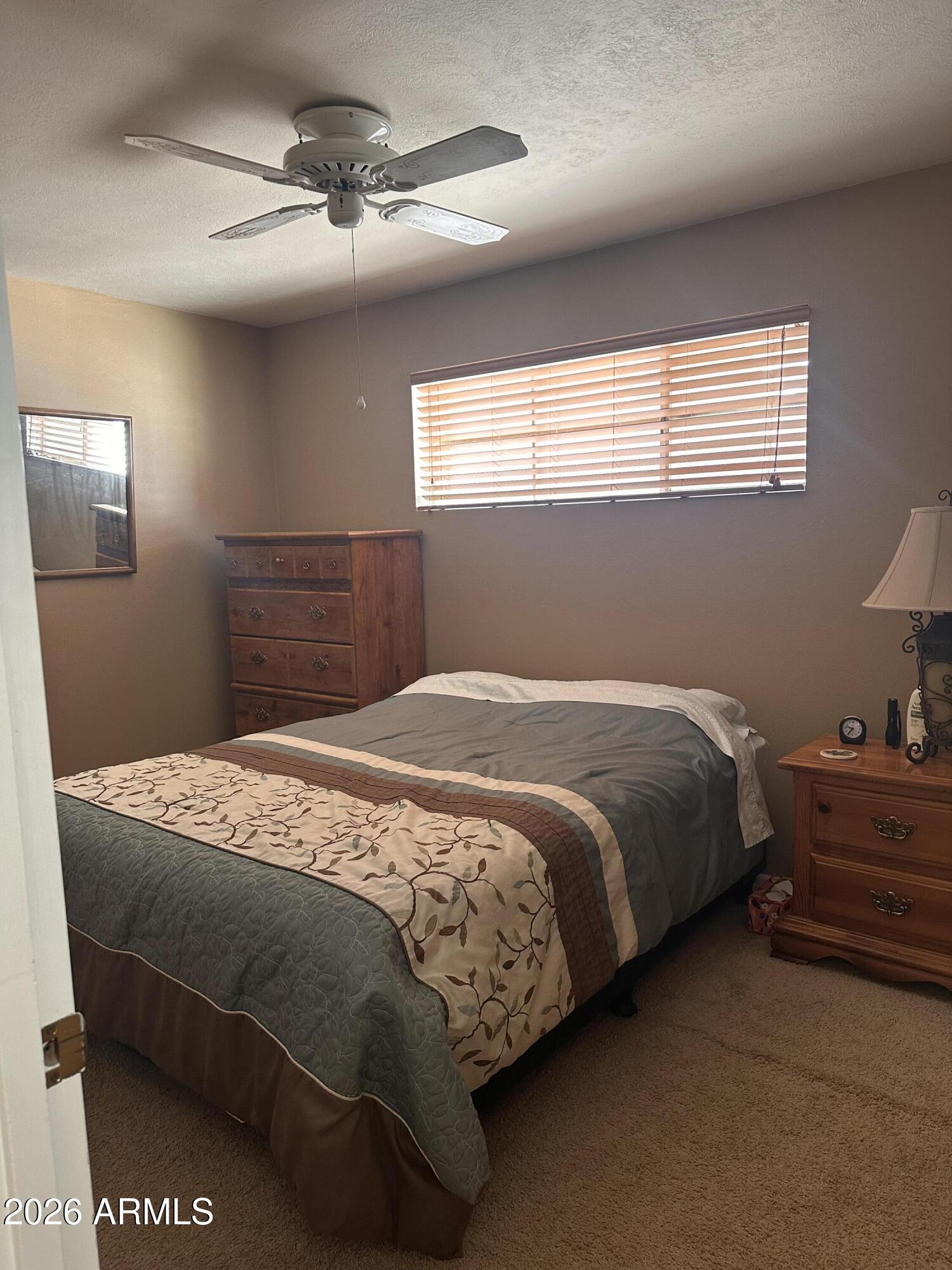 2821 West Elliot Road Laveen, AZ 85339 - Photo 40 of 92 a bedroom with a bed and dresser with mirror