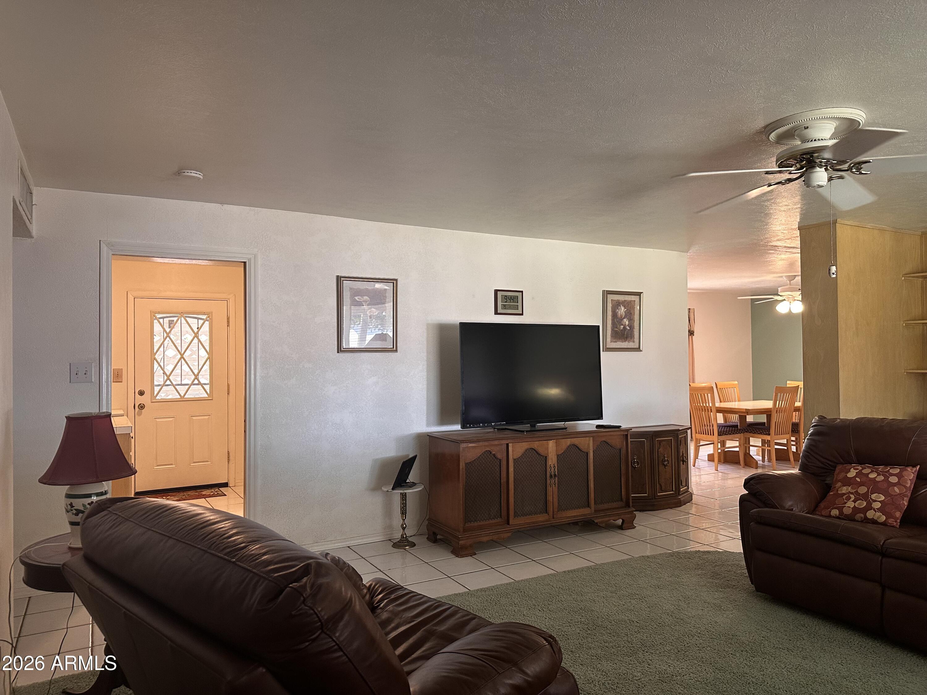 2821 West Elliot Road Laveen, AZ 85339 - Photo 10 of 92 a living room with furniture and a flat screen tv