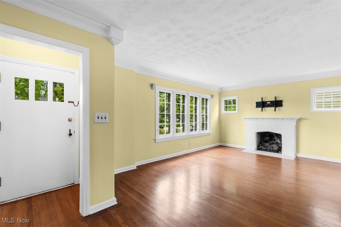 1492 Lyndhurst Road Lyndhurst, OH 44124 - Photo 5 of 32 Living room with plenty of natural light, wood floors, fireplace, crown molding, and a textured ceiling