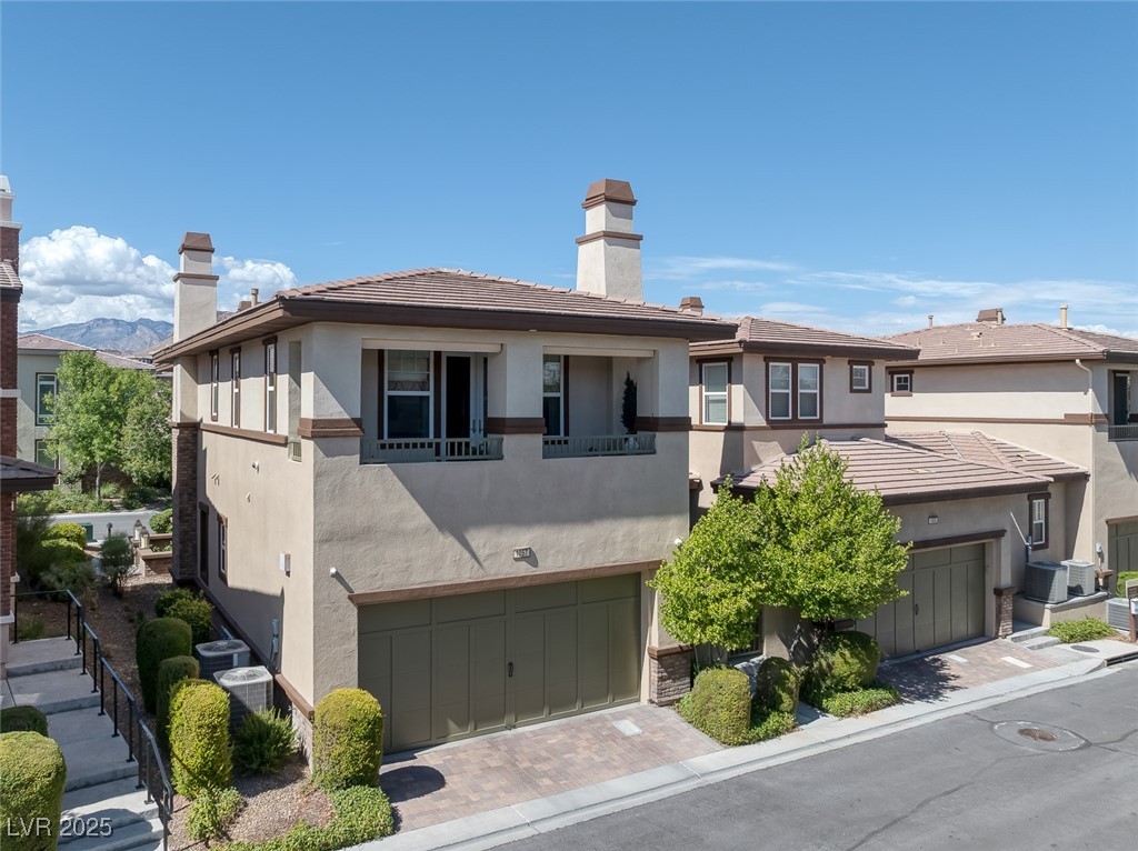 11280 Granite Ridge Drive, Unit 1057 Las Vegas, NV 89135 - Photo 32 of 46 View of front facade with stucco siding, a chimney, decorative driveway, a tile roof, and an attached garage